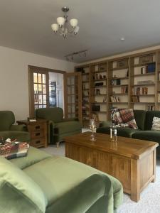 a living room with green furniture and a coffee table at Richmond, Keswick town centre apartment in Keswick +12 photos