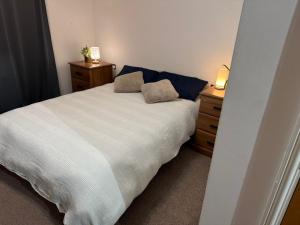 Un dormitorio con una cama blanca y dos mesitas de noche. en Beautiful room- private bathroom, en Harrow