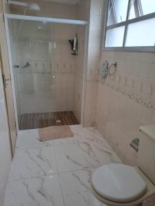 ein Badezimmer mit Dusche und Toilette in der Unterkunft Recanto da Felicidade in Guarujá