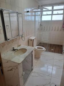 ein Badezimmer mit Waschbecken und Toilette in der Unterkunft Recanto da Felicidade in Guarujá + 7 Fotos