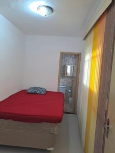 1 Schlafzimmer mit einem roten Bett und einem Badezimmer in der Unterkunft Recanto da Felicidade in Guarujá