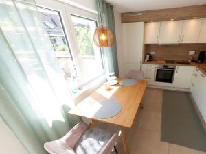a small kitchen with a wooden table and a window at Bei Heussens in Waldbronn