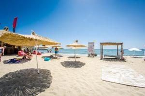 ein Strand mit Sonnenschirmen und Menschen auf dem Sand in der Unterkunft Premier Fort Beach Resort in Sonnenstrand + 86 Fotos