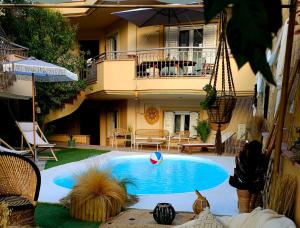 a swimming pool in front of a house with an umbrella at Nefeli Villa lagonisi - Pool in Lagonissi