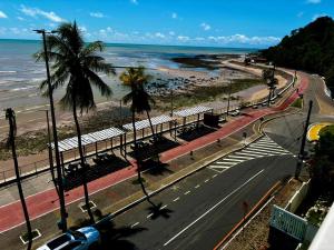 una calle con palmeras y una playa con el océano en Blue Sunset Family Experience - Aptos 101 - 220 - 223 - 224 - 311, en João Pessoa