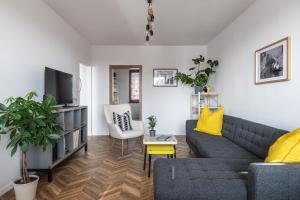 a living room with a couch and a tv at The Nest - Komárno in Komárno