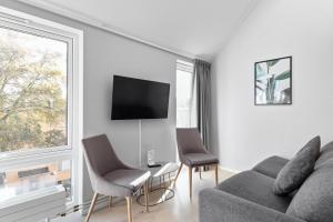 a living room with a couch and chairs and a tv at Avanti Apartment Hotel in Stockholm