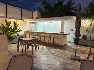 a patio with a table and chairs and a bar at Hotel Casa Vivaldi in Mérida