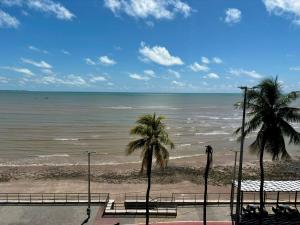 Una vista de una playa con palmeras y el océano en Blue Sunset Family Experience - Aptos 101 - 220 - 223 - 224 - 311, en João Pessoa