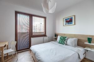 a bedroom with a bed and a desk and a window at The Nest - Komárno in Komárno