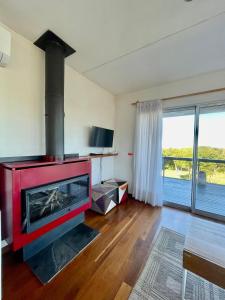 a living room with a red fireplace with a view at Delamar suites in La Paloma