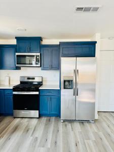 a kitchen with blue cabinets and a refrigerator at The Ostel in Los Angeles +1 photo