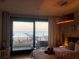 a bedroom with a large window with a view of the ocean at StrandSUITE Scharbeutz Meerblick in Scharbeutz
