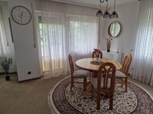 a dining room with a table and chairs and a clock at Grimm Apartment 2 in Kassel