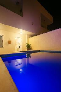 a swimming pool with blue lighting in a house at Bahia Bela - Casa Duplex 02 in Santa Cruz Cabrália