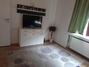 a living room with a flat screen tv on a white cabinet at Wohnen auf Zeit HF in Herford