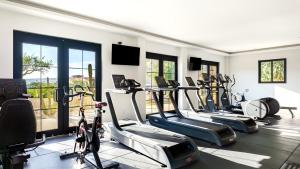 a gym with several treadmills and exercise bikes at Stunning 2BR Condo - 5 Min to Beach in Cabo San Lucas