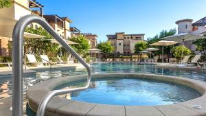 a swimming pool with a hot tub in a building at Stunning 2BR Condo - 5 Min to Beach in Cabo San Lucas
