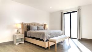 a white bedroom with a bed and a window at Stunning 2BR Condo - 5 Min to Beach in Cabo San Lucas +25 photos