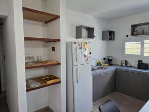 a kitchen with a white refrigerator and gray cabinets at Casa Azul in Neuquén