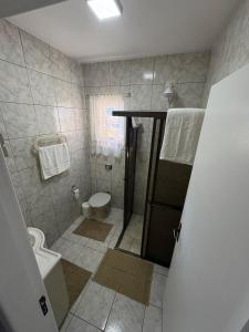 a bathroom with a toilet and a sink and a shower at Casa - Joinville in Joinville +14 photos