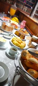 Una mesa con muchos platos de comida encima. en Hotel São Francisco, en Itaí
