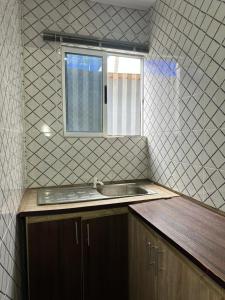 a small kitchen with a sink and a window at Dee Rocket Hotel & Lounge in Ibadan
