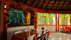 a restaurant with tables and chairs and a painting on the wall at Hotel Mirador Maya Calakmul in Xpujil
