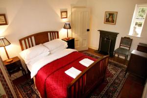 een slaapkamer met een groot bed en een rode deken bij Triumphal Arch Lodge in Creagh