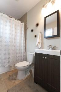 a bathroom with a toilet and a sink and a mirror at Modern Loft Retreat - North Park San Diego in San Diego