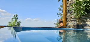a person sitting next to a swimming pool at Villa Leon in Jarabacoa