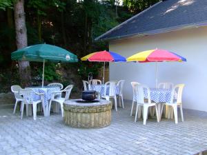un groupe de tables et de chaises avec parasols dans l'établissement Relax Apartmans, à Balatonszemes