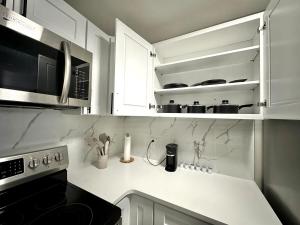 eine Küche mit weißen Schränken und einem Herd mit Backofen in der Unterkunft Private Entrance Cozy Apt Bright Modern in Albany + 11 Fotos