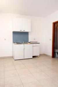 an empty kitchen with white cabinets and a tile floor at Apartments by the sea Zaton Veliki, Dubrovnik - 2107 in Zaton +21 photos