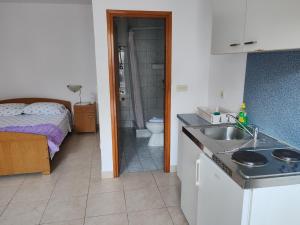 a kitchen with a sink and a bathroom with a bed at Apartments by the sea Zaton Veliki, Dubrovnik - 2107 in Zaton