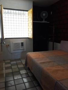 a bedroom with a bed and a window and a tiled floor at Maravista in Itamaracá