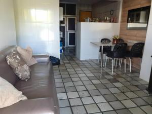 a living room and kitchen with a couch and a table at Maravista in Itamaracá