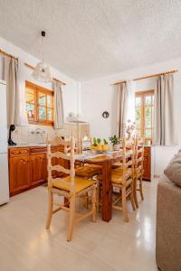 a kitchen with a wooden dining room table and chairs at Querencia Residence in Khánia