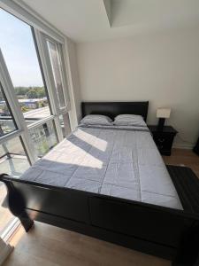 a large bed in a room with a large window at Vibrant 1 Bedroom Condo Apt in Toronto +40 photos