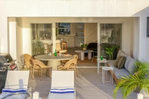 a patio with chairs and a table and a couch at Wadadli Breeze in Jolly Harbour