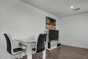 an office with a glass desk and black chairs at Large Modern 1-Bedroom With Dining Area In Central Location Close To Downtown LA in Los Angeles +5 photos