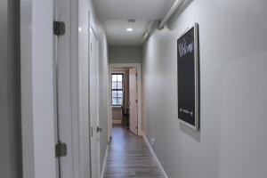 2 BEDROOM 1 BATH TRENDY Apt Downtown Albany في ألباني: ممر به جدران بيضاء وبه علامة على الحائط