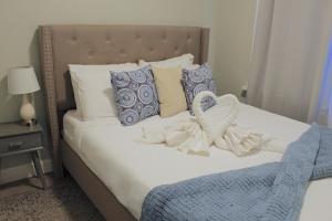 2 BEDROOM 1 BATH TRENDY Apt Downtown Albany في ألباني: غرفة نوم مع سرير ووسائد زرقاء وبيضاء