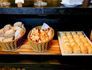 tres cestas de pan y pastas en una mesa en Alugueasy - Nobile Suites Monumental, en Brasilia