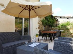 a patio with an umbrella and a table and chairs at Gîte rénové 3 chambres avec cour et terrasse, proche musée et voie verte vers le lac du Der - FR-1-611-63 in Dommartin-le-Franc +6 photos