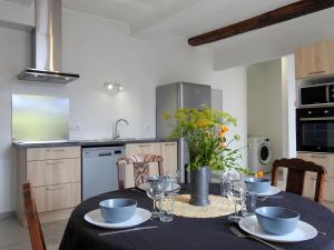 a kitchen with a table with a black table cloth at Gîte rénové à Dommartin-le-Franc : confort, verdure et activités à proximité du lac du Der - FR-1-611-64 in Dommartin-le-Franc