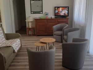 ein Wohnzimmer mit Sofa, Stühlen und einem Tisch in der Unterkunft Confort en famille proche de Giffaumont - FR-1-611-112 in Braucourt