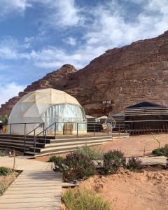 a large glass building in front of a mountain at Sofia Valley Camp in Wadi Rum