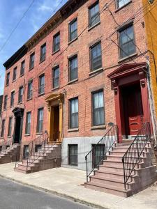 a red brick building with stairs in front of it at Beautiful 2 BED 2 BATH Soaker Tub in Albany
