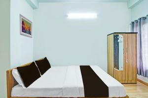 a bedroom with a bed and a wooden door at Hotel O Assam Inn Grand in Guwahati